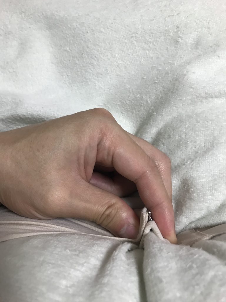 ブラジャーのはずし方の手順画像：②「親指」と「人差し指」でホックをつまむ